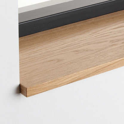 Detail van de eiken gefineerde vensterbank met zijdeglans blanke lak onder het raam.