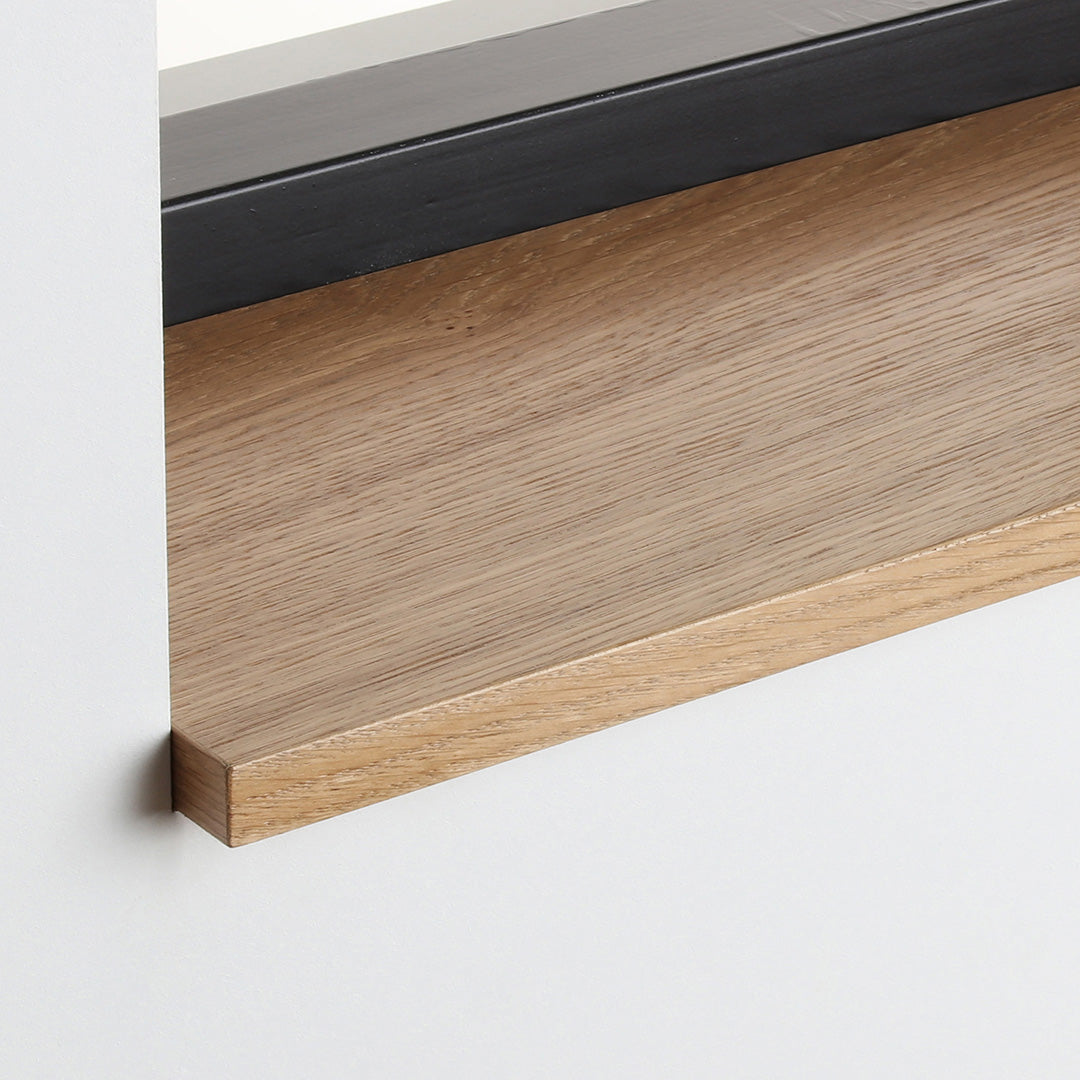 Detail van de eiken gefineerde vensterbank Sandstone met zijdeglans beits onder het raam.