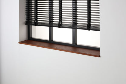 Eiken gefineerde vensterbank Smoked Oak met matte beits onder een zwart raam met jaloezieën.