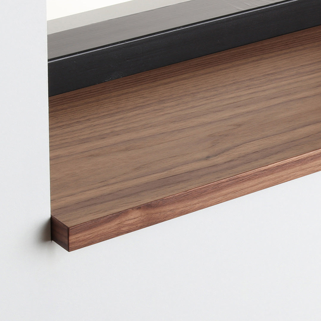 Detail van de noten gefineerde vensterbank met matte blanke lak onder het raam.